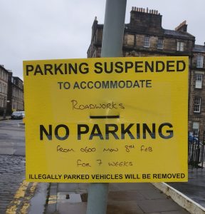Yellow Parking Sign on lamp post.