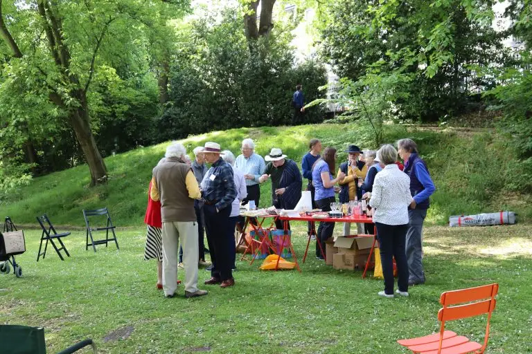 Party guests and table in gardens.