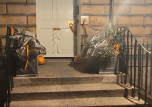 White door with pumpkins and webs around.