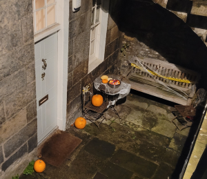 White basement door with pumpkins around and tray of sweets.