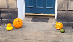 Front door with pumpkins at either side.