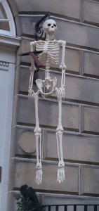 White door with full skeleton hanging from light hook.