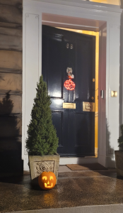 Slightly open door with pumpkin in front.